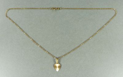 un collier plaqué or orné d'un petit coquillage, monté sur une chaîne en or