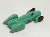 a green toy car that is sitting on a white surface