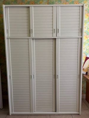 une armoire blanche avec des volets, dans un coin de la pièce