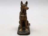 bronze statue of a dog sitting on a black base