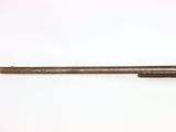 an old gun with a wooden barrel on a white surface