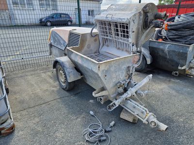 un camion équipé d'une cage à l'arrière, garé à côté d'autres camions