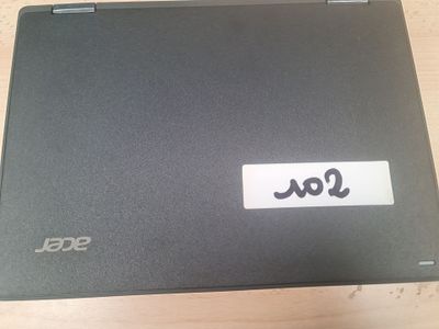 un ordinateur portable sur lequel est collé un autocollant, posé sur une table