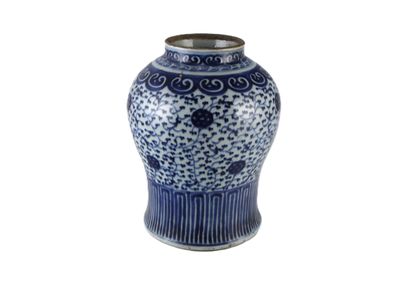 un vase bleu et blanc posé sur une surface blanche