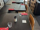 many tables and chairs in this restaurant with red napkins