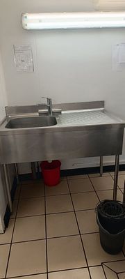 une salle de bains avec un lavabo et des seaux posés par terre