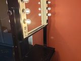 une photo d'une coiffeuse avec un miroir et des lumières