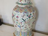 a vase with a lid on a stand on the floor