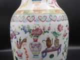 a white vase with colorful designs on it sitting on a table