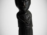 une image représentant une statue en bois d'un homme tenant un couteau