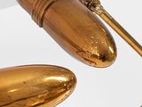 a gold desk lamp that is sitting on a white surface