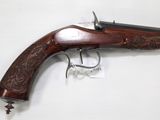 a gun that is on display on a white surface