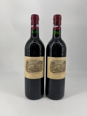 deux bouteilles de vin rouge posées l'une à côté de l'autre sur une surface blanche