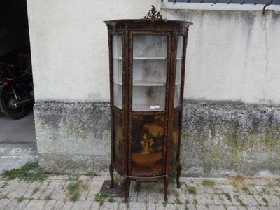 une armoire d'angle ornée d'un tableau, devant un immeuble