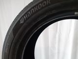 a close up of a tire on a white surface with a white curtain in the background