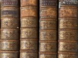 plusieurs vieux livres sont empilés sur une étagère