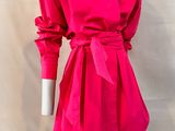 the mannequin is wearing a bright pink dress with a belt