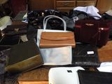 many bags and purses sitting on a table