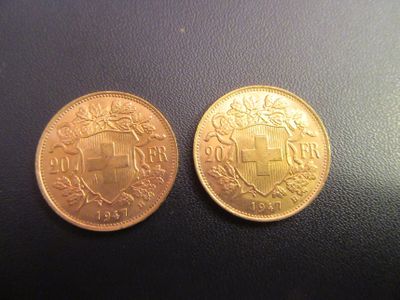 deux pièces d'or ornées d'un blason, posées sur un fond noir