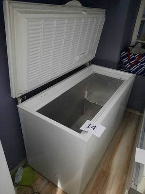 a white chest freezer sitting on a wooden floor