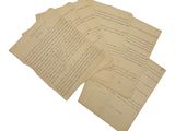 plusieurs morceaux de vieux papier comportant des inscriptions, posés sur une surface blanche