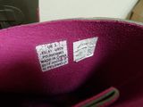 someone is holding a pink purse with a tag on it