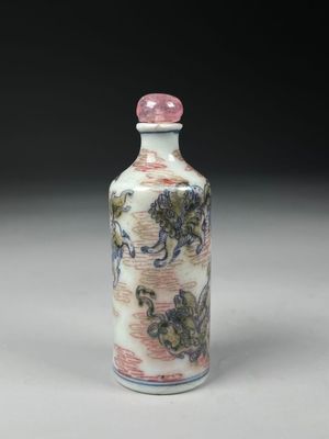 une petite bouteille ornée d'une peinture, posée sur une table