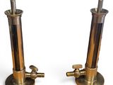 pair of brass plated candles on pedestals on a white background