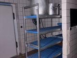 shelves with pots and pans on top of them in a kitchen