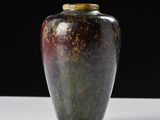 a vase that is sitting on a table with a black background