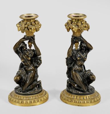 pair of bronze figurines of a man and woman with baskets on their heads