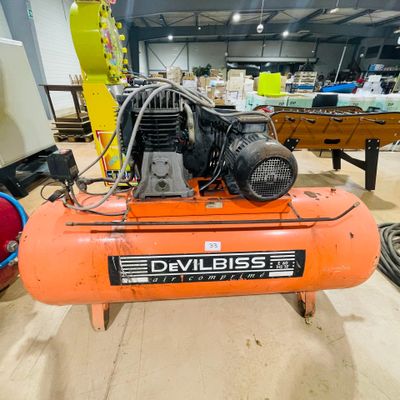 an orange air compressor sitting on top of a table in a room