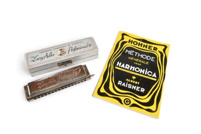 une image représentant un harmonica et son étui posés sur une surface blanche