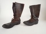 pair of brown leather boots with laces on them on a white surface