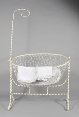 un lit de bébé ancien en métal, avec un livre à l'intérieur