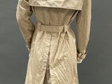 an image of a mannequin wearing a beige trench coat and black pants