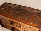 an old wooden dresser with many drawers and a teddy bear