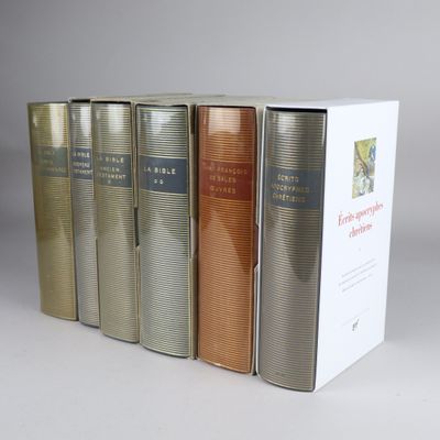 three books are lined up in a row on a white surface