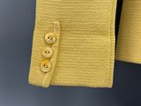 le dos d'une veste jaune à boutons sur fond gris