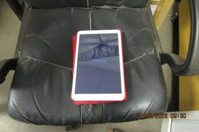 une tablette posée sur un fauteuil en cuir noir dans une pièce