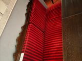 a red and black striped chair next to a mirror on the wall