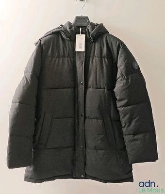 a close up of a jacket hanging on a hanger on a wall