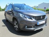 La voiture grise est garée sur le parking près d'un immeuble.