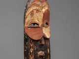 a wooden mask with a face and a long nose