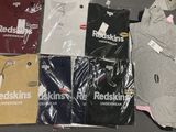 un grand nombre de t-shirts posés sur une table