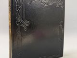un livre noir posé sur une table blanche