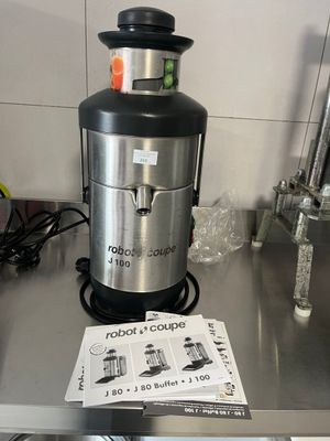 a silver and black juicer sitting on top of a metal counter