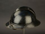 a silver helmet on a metal stand on a dark background