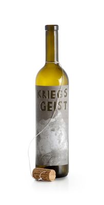 the bottle of wine is next to a cork on a white surface