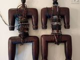 two wooden figurines hanging on a wall